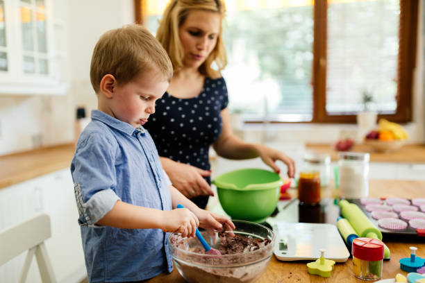 istock Child helping mother make muffins 876136428