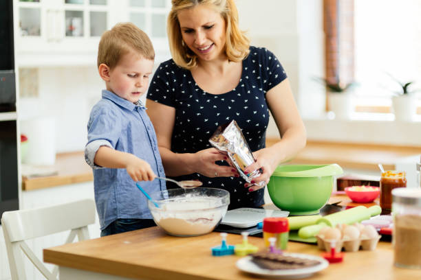 istock Smart cute child helping mother in kitchen 876136684