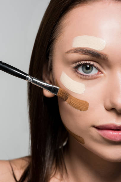istock woman applying tonal foundation on face 876146674