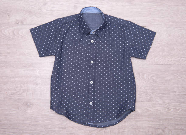 istock Dark blue polka dot shirt for boys on wood background. 876147018