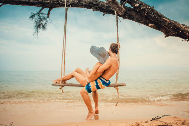istock Couple sitting at rope swings 876168082