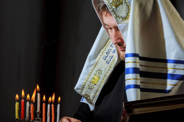 istock male hand lighting candles in menorah on table Hanukkah 876168214
