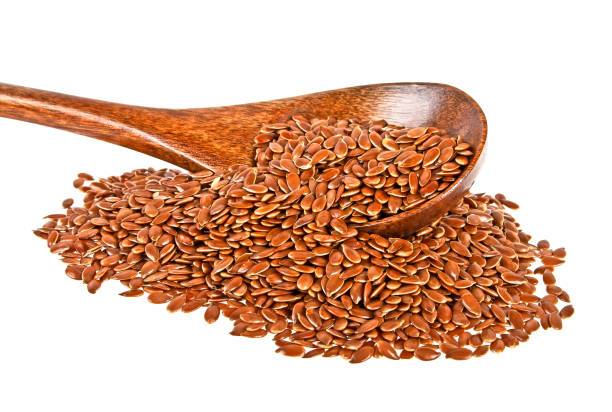 istock Flax seeds in wooden spoon isolated on a white background 876173356