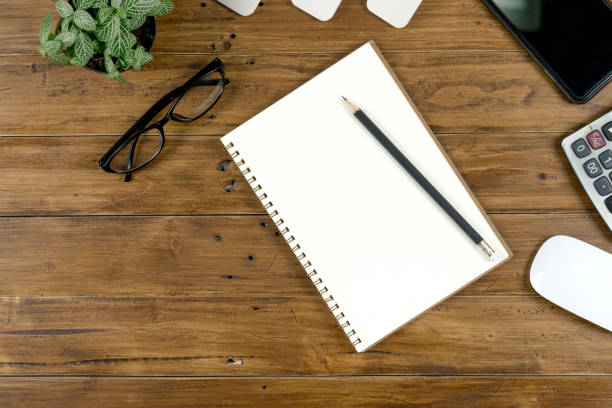 istock Office work table with tablet , notebook and stationary on brown wood desk table , Topview with workspace for add text or graphic 876178082