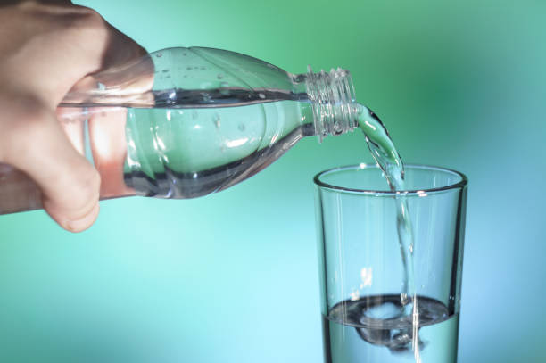 istock water is poured into a glass on green and blue  soft focus background 876186236