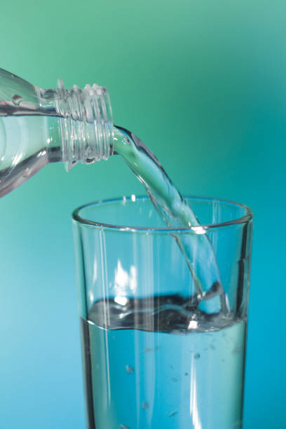 istock water is poured into a glass on green and blue  soft focus background 876186482