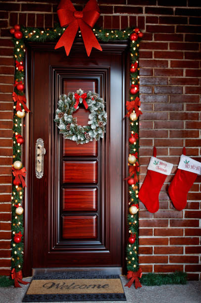 украшенная дверь накануне рождества - wreath christmas door snow стоковые фото и изображения