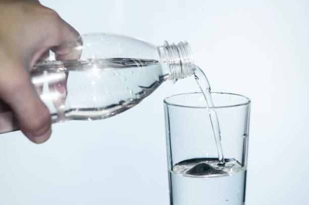 istock water is poured into a glass on white isolated background 876187218