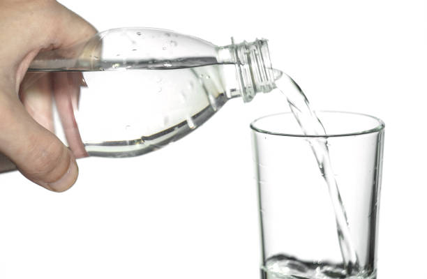 istock water is poured into a glass on white isolated background 876187394