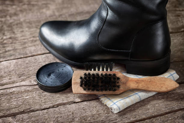 istock Black boot on cloth with wooden brush 876187396
