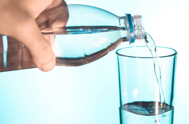 istock water is poured into a glass on white isolated background 876187786
