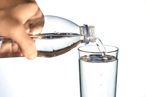 istock water is poured into a glass on white isolated background 876189940