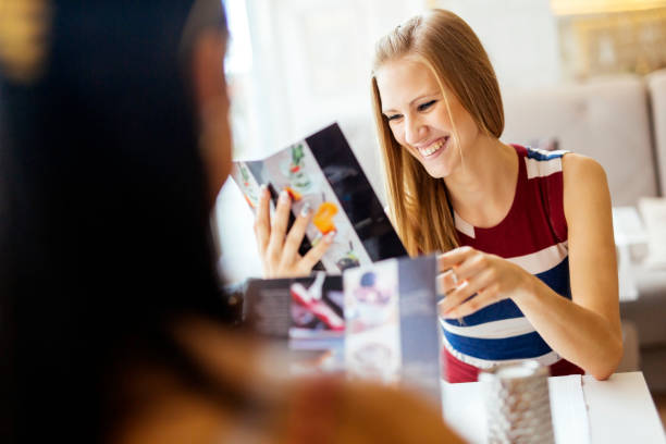 istock Two beautiful women looking at menu 876191022