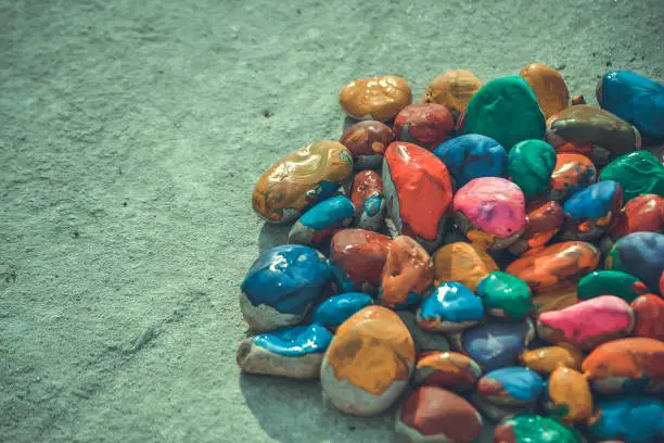stones with a smooth surface painted with multicolored paint, filter and close-up view from above