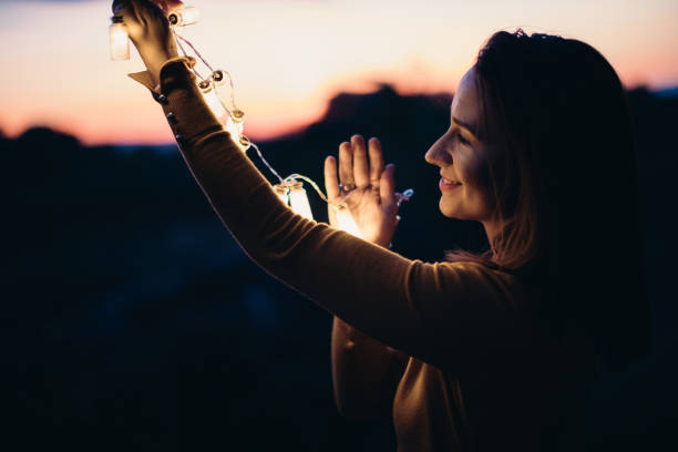 istock Girl holding lights in sunset 876192566