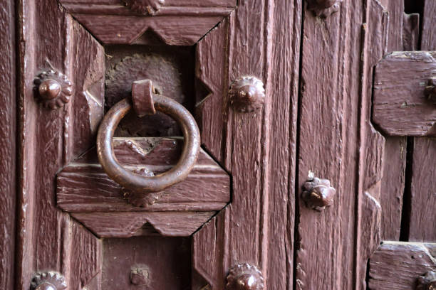 istock Old doorknob on vintage red door in India 876195004