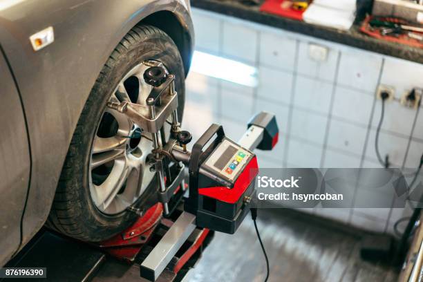 Closeup Of Tire Clamped With Aligner Undergoing Auto Wheel Align Stock Photo - Download Image Now