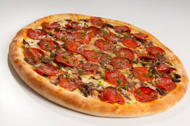 Pizza baked in the oven with tomato sauce and topped with mozarella cheese, pepperoni, flié mignon and oregano
