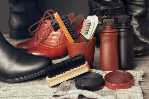 Brushes, cloth and polish cream for shoes and boots on wooden table