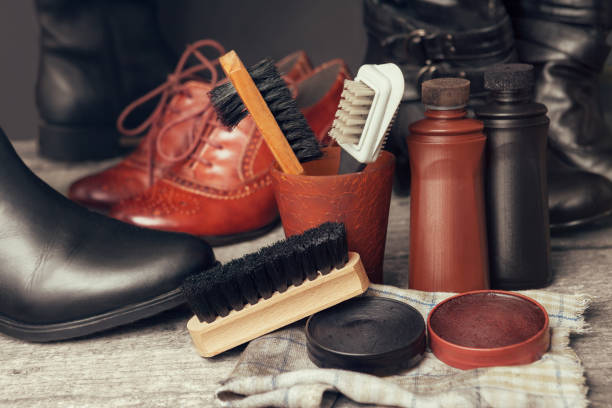 Brushes and polish cream for shoes Brushes, cloth and polish cream for shoes and boots on wooden table shoe polish photos stock pictures, royalty-free photos & images