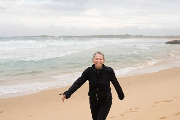 istock Older woman laughing at the beach 876216462