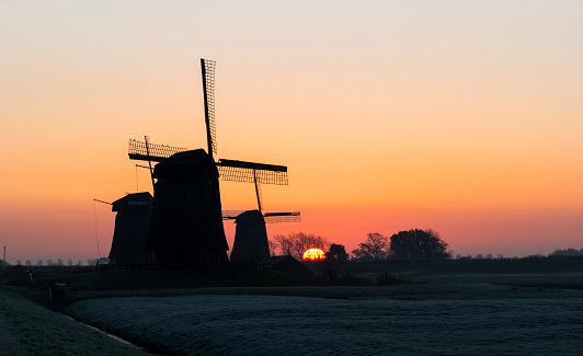 Sunrise between three windmills near Schermerhorn, Netherlands