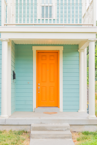 Freshly painted home with tangerine door and baby blue siding