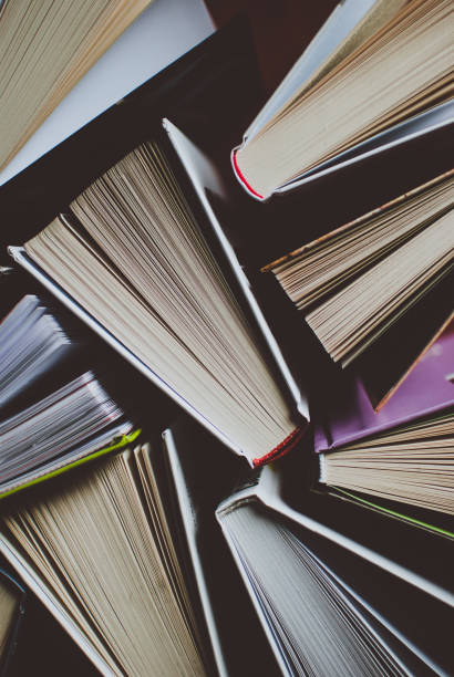 istock Open new colorful books standing on the wooden table. 876273088