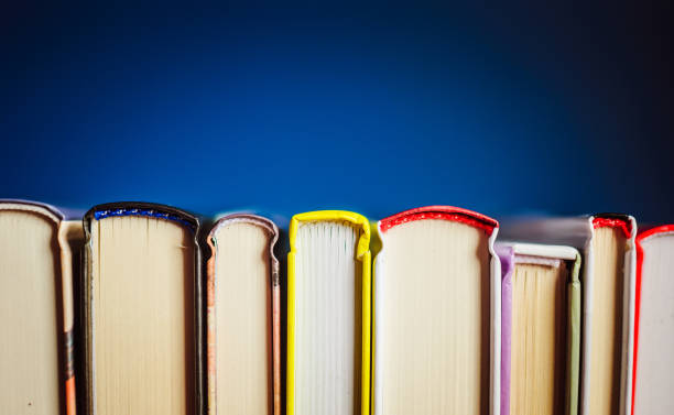 istock Open new colorful books standing on the wooden table. 876273228
