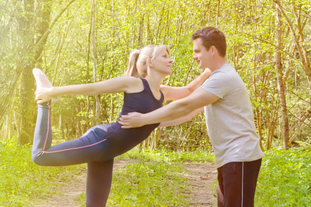 istock Young couple stretching legs before running in summer nature. 876273590