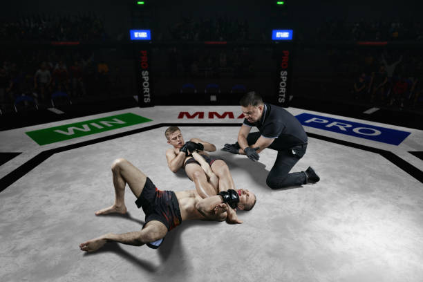 referee is stopping mma fight after the submission move - confined space flash imagens e fotografias de stock
