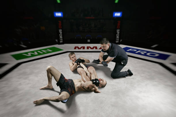 referee is stopping mma fight after the submission move blurred - confined space flash imagens e fotografias de stock