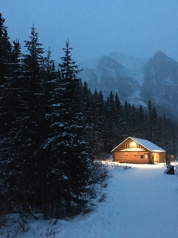 A log cabin brightens the winter mountains