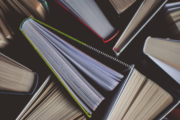 istock Open new colorful books standing on the wooden table. 876275466