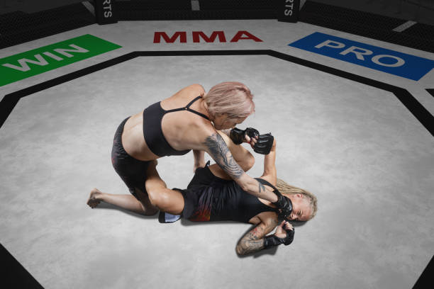 female mma fighter is punched in ground fight, blurred - confined space flash imagens e fotografias de stock