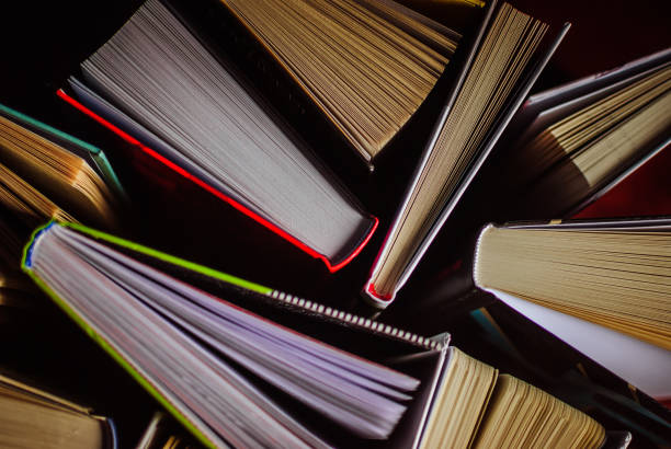 open new colorful books standing on the wooden table. - proof of love imagens e fotografias de stock