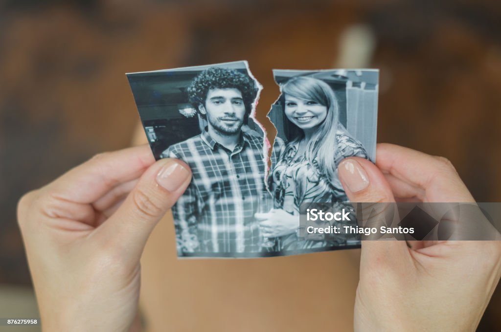 Great concept of divorce. Great concept of divorce, betrayal, separation, woman hand ripping photo of the couple. Photograph Stock Photo