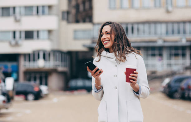 istock Woman texting and drinking coffee in the city 876276078