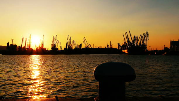 Photo of cargo port cranes silhouette on sunset