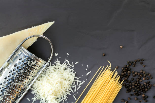 Ingredients for pasta with pecorino and pepper.  Top view over dark slate.  Traditional Italian food.