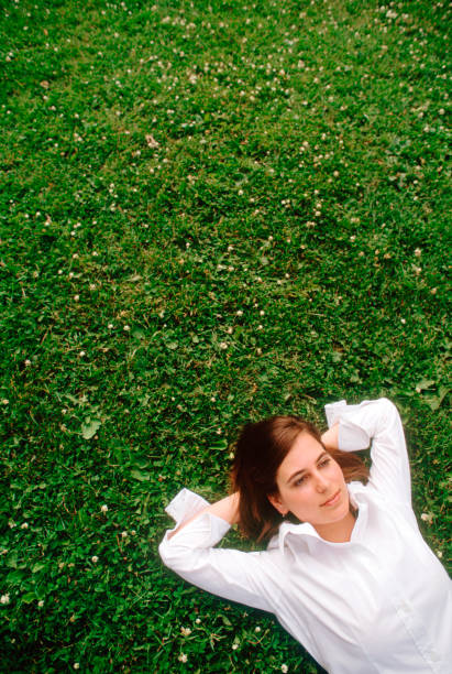 istock Young woman laying on grass. 876279712