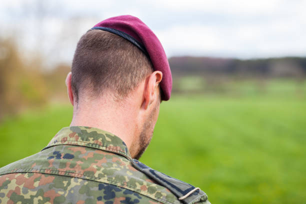 istock german soldier with a beret stands on a field background 876303510