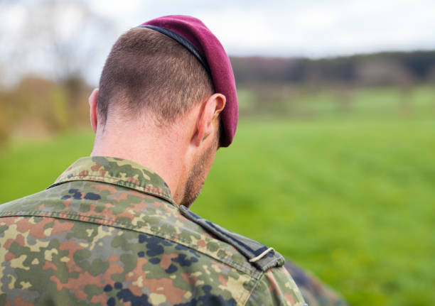 istock german soldier with a beret stands on a field background 876303526