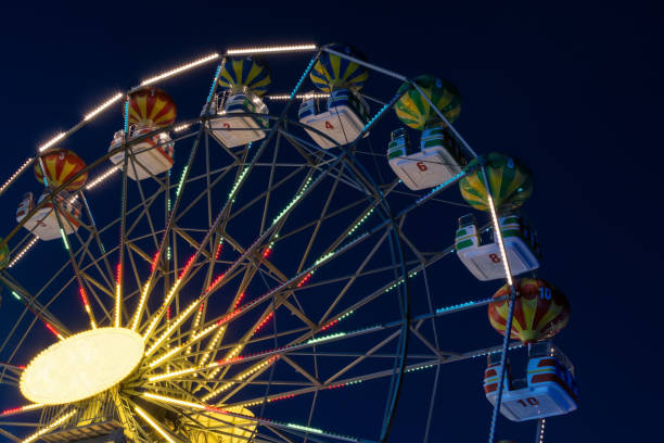 istock Part of a Ferris wheel at night  with changing colors 876306466