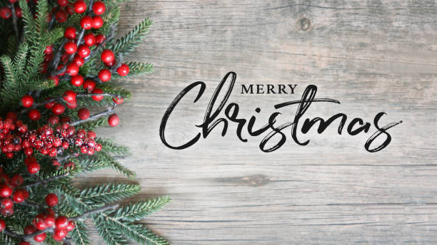 istock Merry Christmas Text with Holiday Evergreen Branches and Berries Over Rustic Wooden Background 876308962