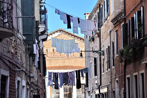 Laundry hanging out on a clotheslines above a street in Venice, Italy.