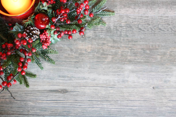 istock Christmas Candle with Pine Tree Branches and Berries in Top Corner Over Rustic Wood 876314966