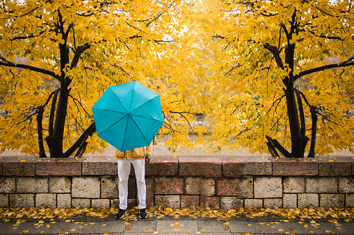 Artistic photography of African man hiding behind an umbrella