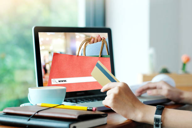 istock Woman hand holding credit card and using laptop computer with blank screen background, shopping on line mock up, template, business and technology concept, digital marketing, casual lifestyle 876317798