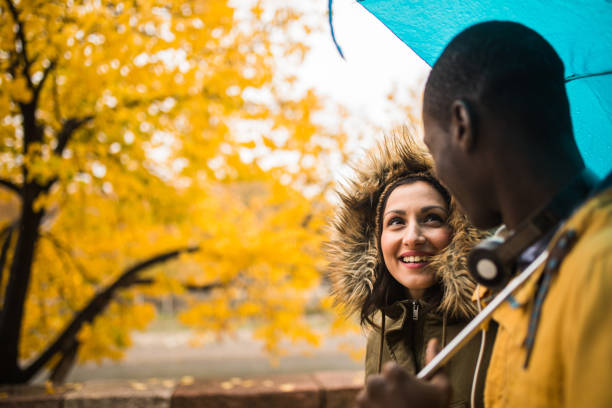 istock Romantic couple sharing an umbrella 876318620